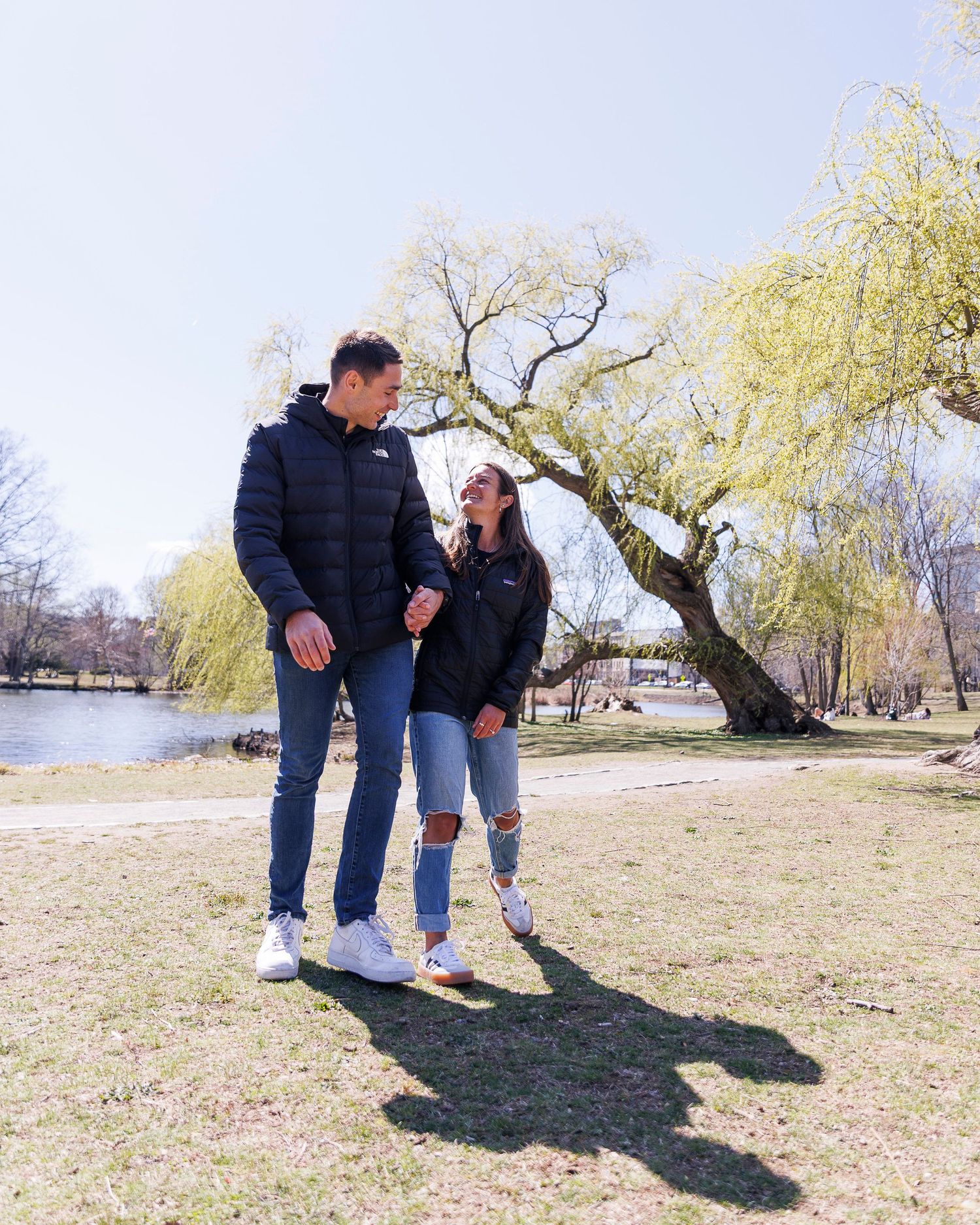 Newly engaged couple holding hands during an engagement session in the Back Bay Fens, a natural park setting located near the Fenway.
