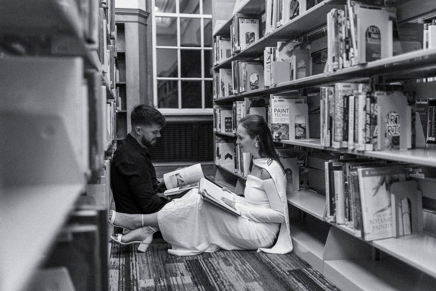 Black and white photo sequence showing a person browsing books in a library aisle, moving from left to right.