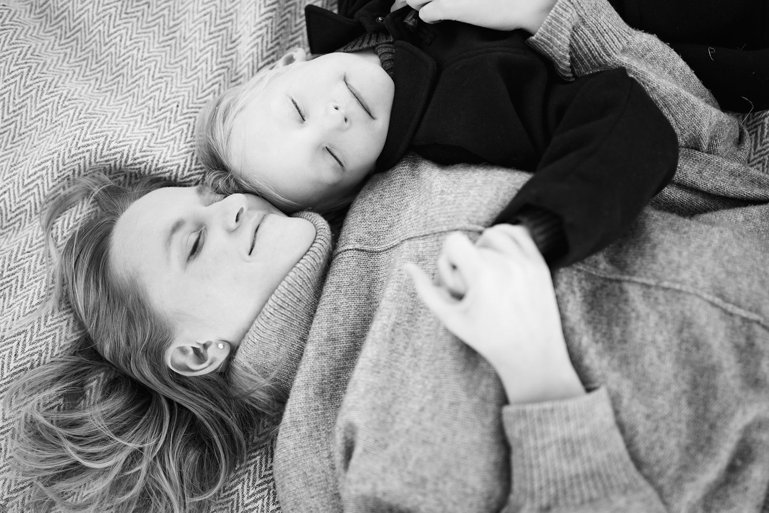 Black and white portrait series showing peaceful resting moments on textured blanket.