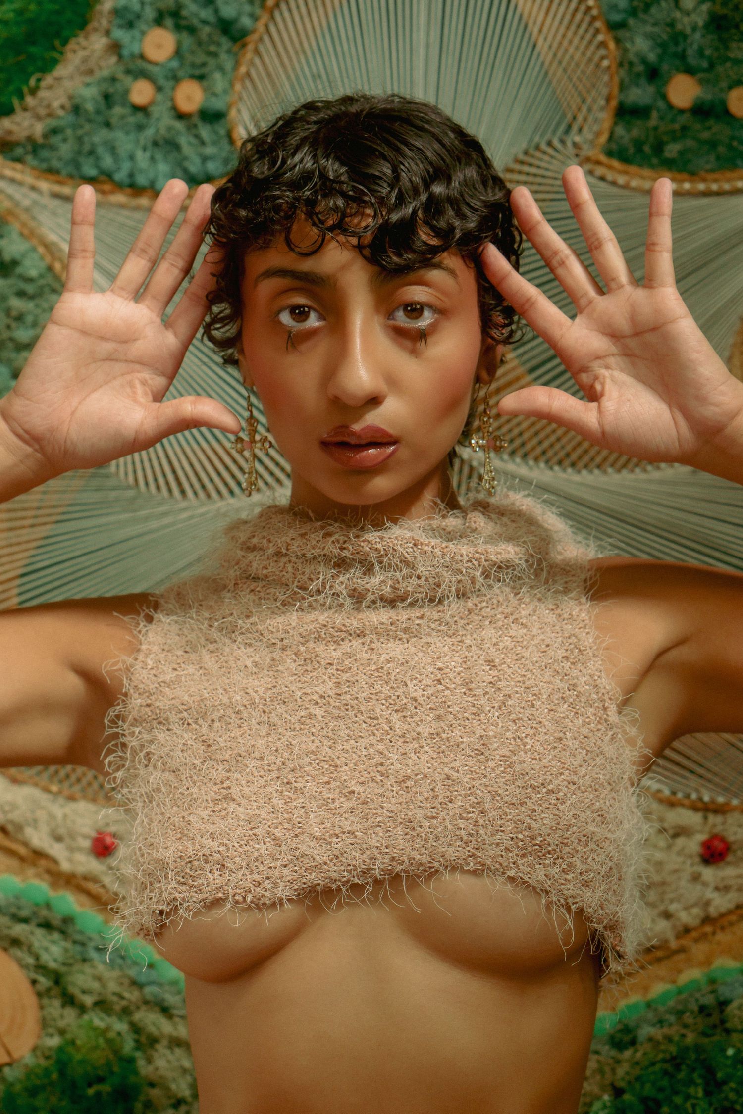 Creative portrait with palm fronds and natural textures creating an artistic composition.