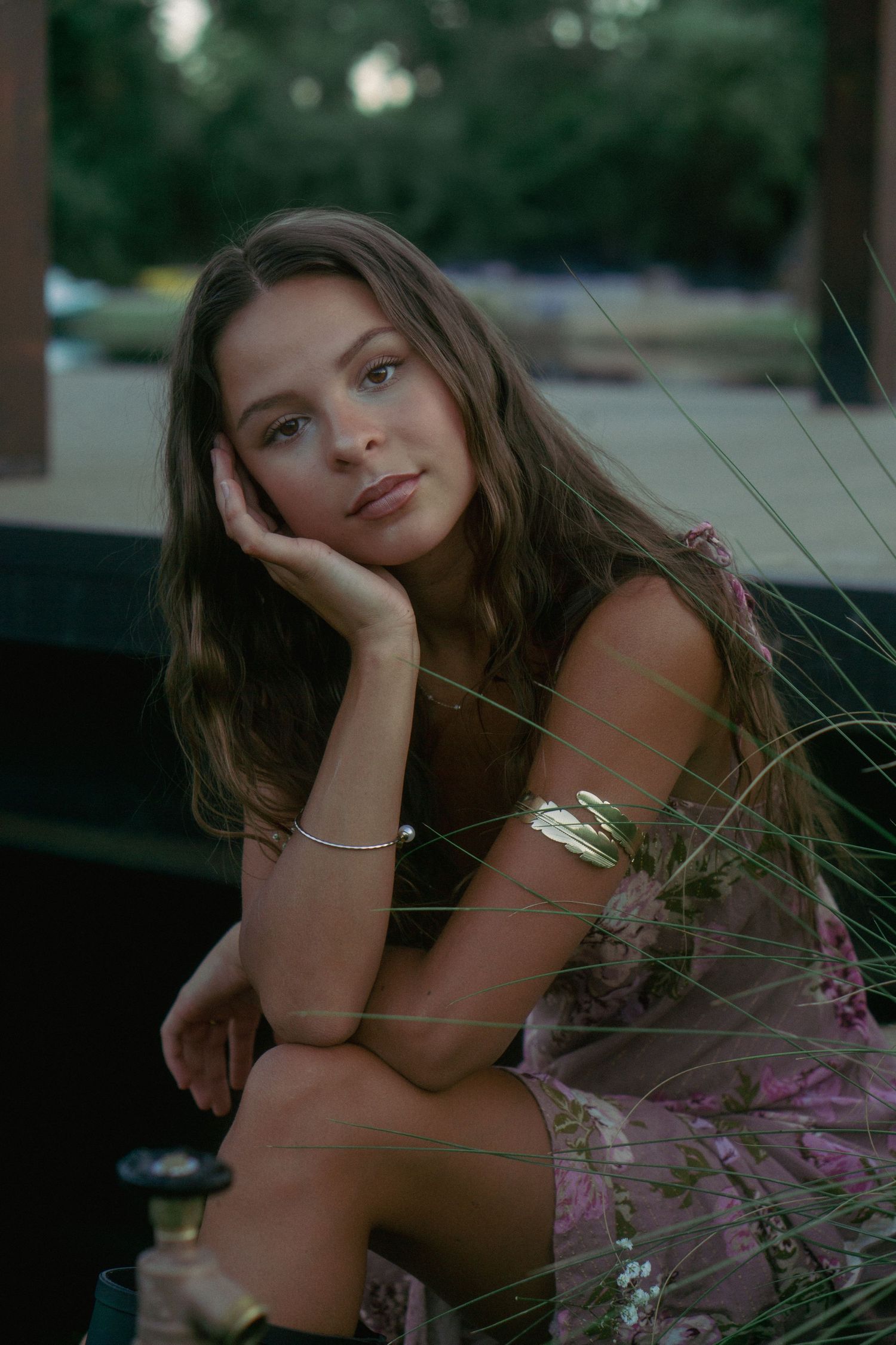 An artistic outdoor portrait with natural lighting and delicate wildgrasses in the foreground.