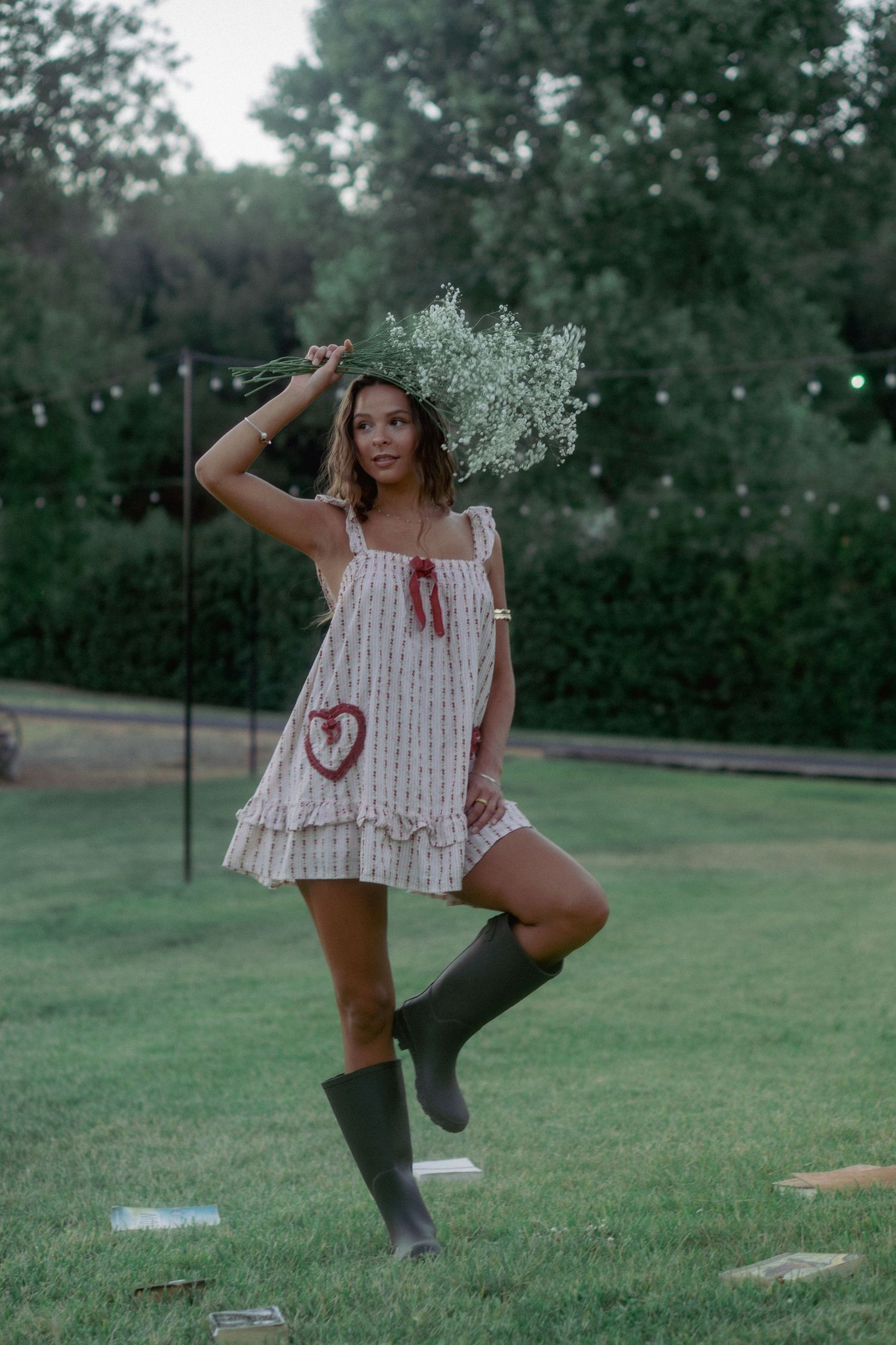 A playful outdoor photoshoot featuring white summer dress and tall boots.