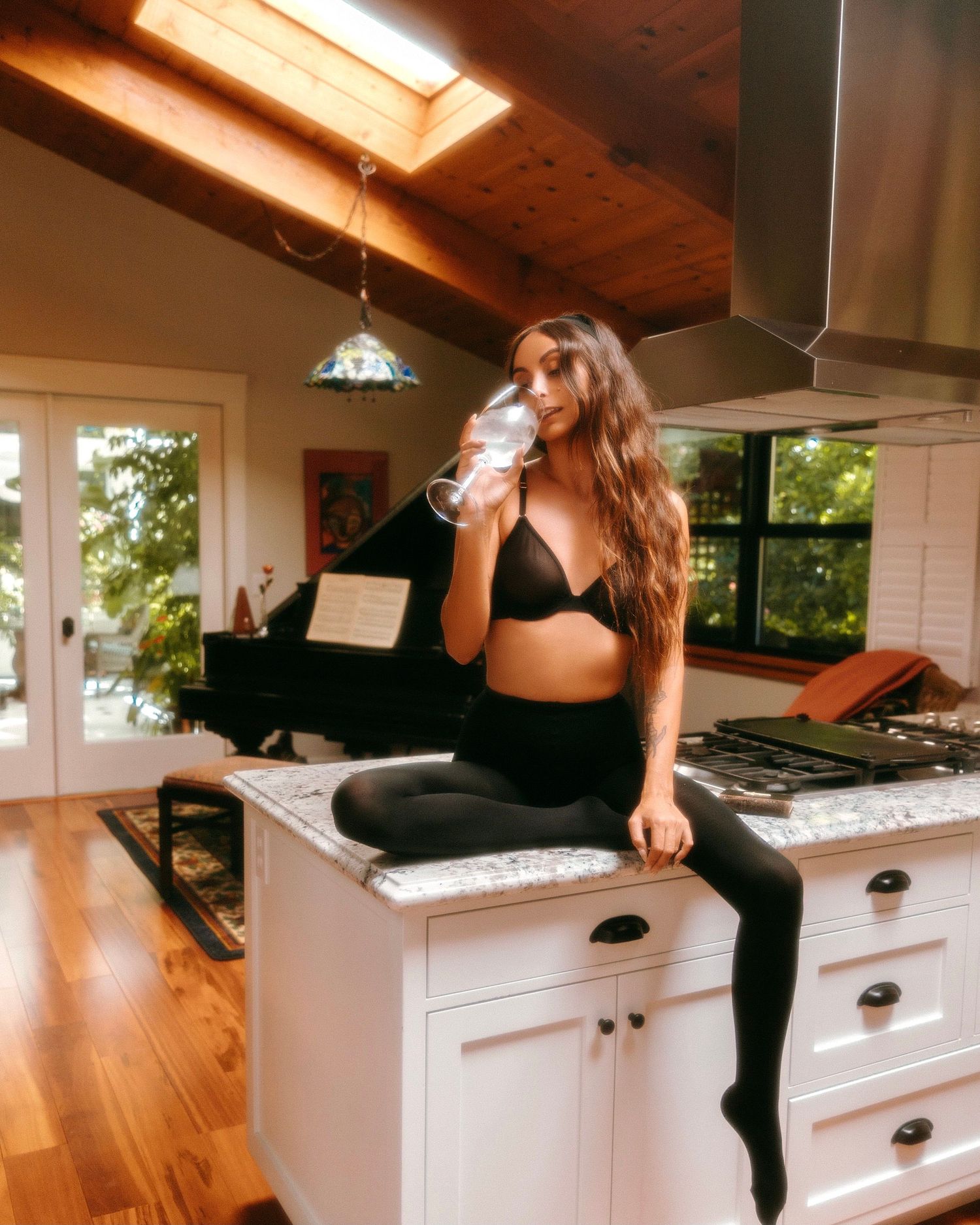 Series of images showing someone climbing onto a white kitchen counter in black athletic wear.