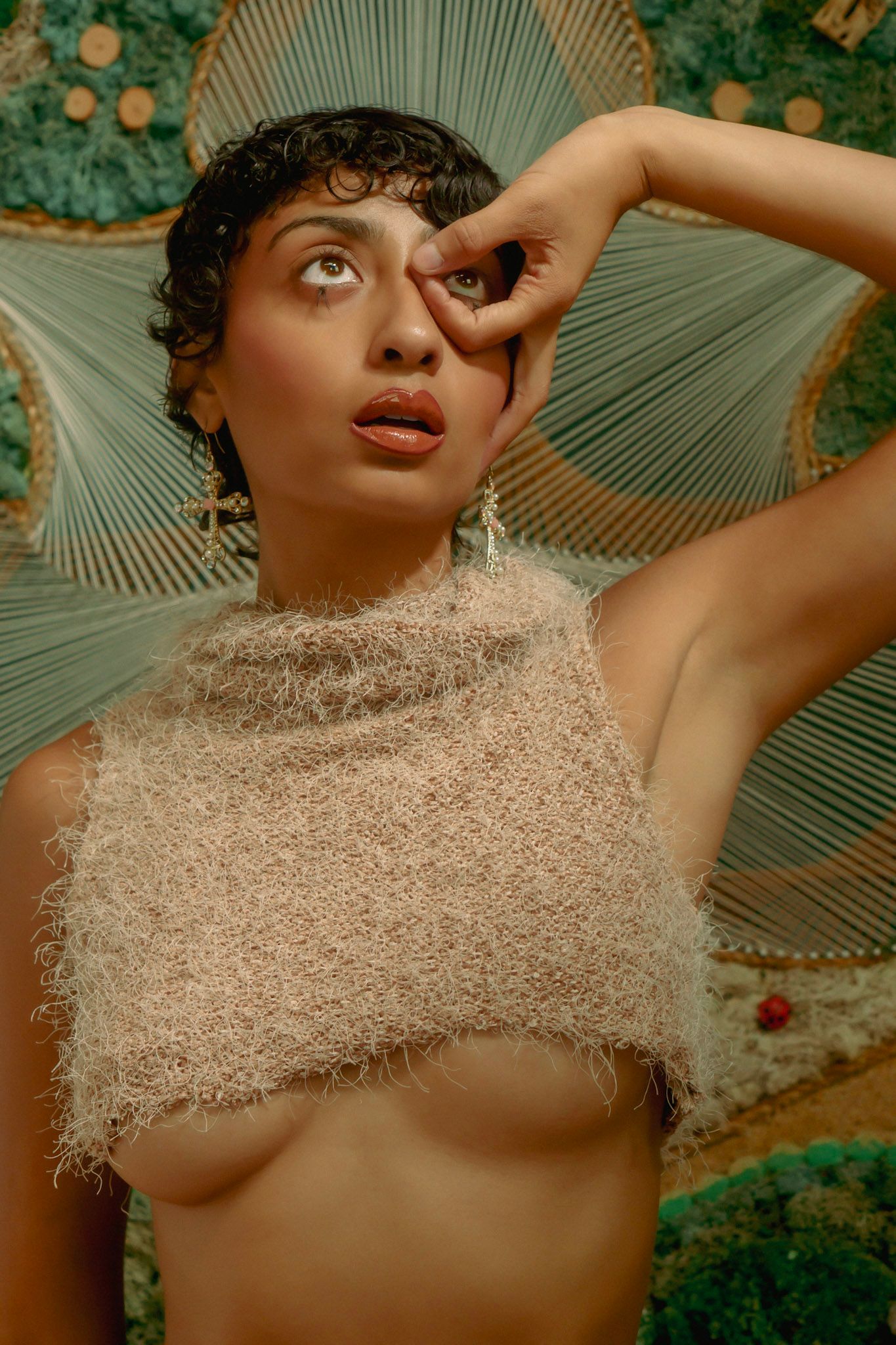 Artistic portrait with textured top against nature-inspired backdrop.