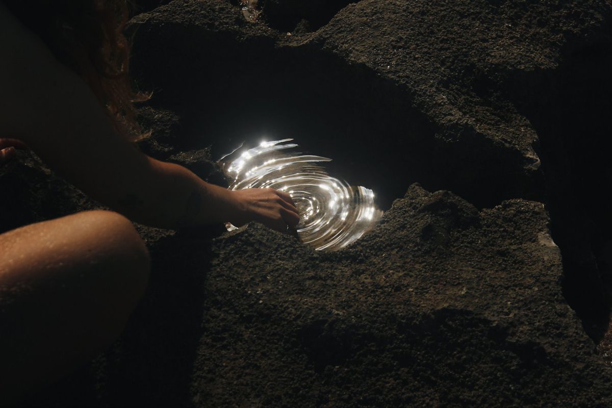 Mysterious dark cave interior with glowing light beam cutting through shadows.