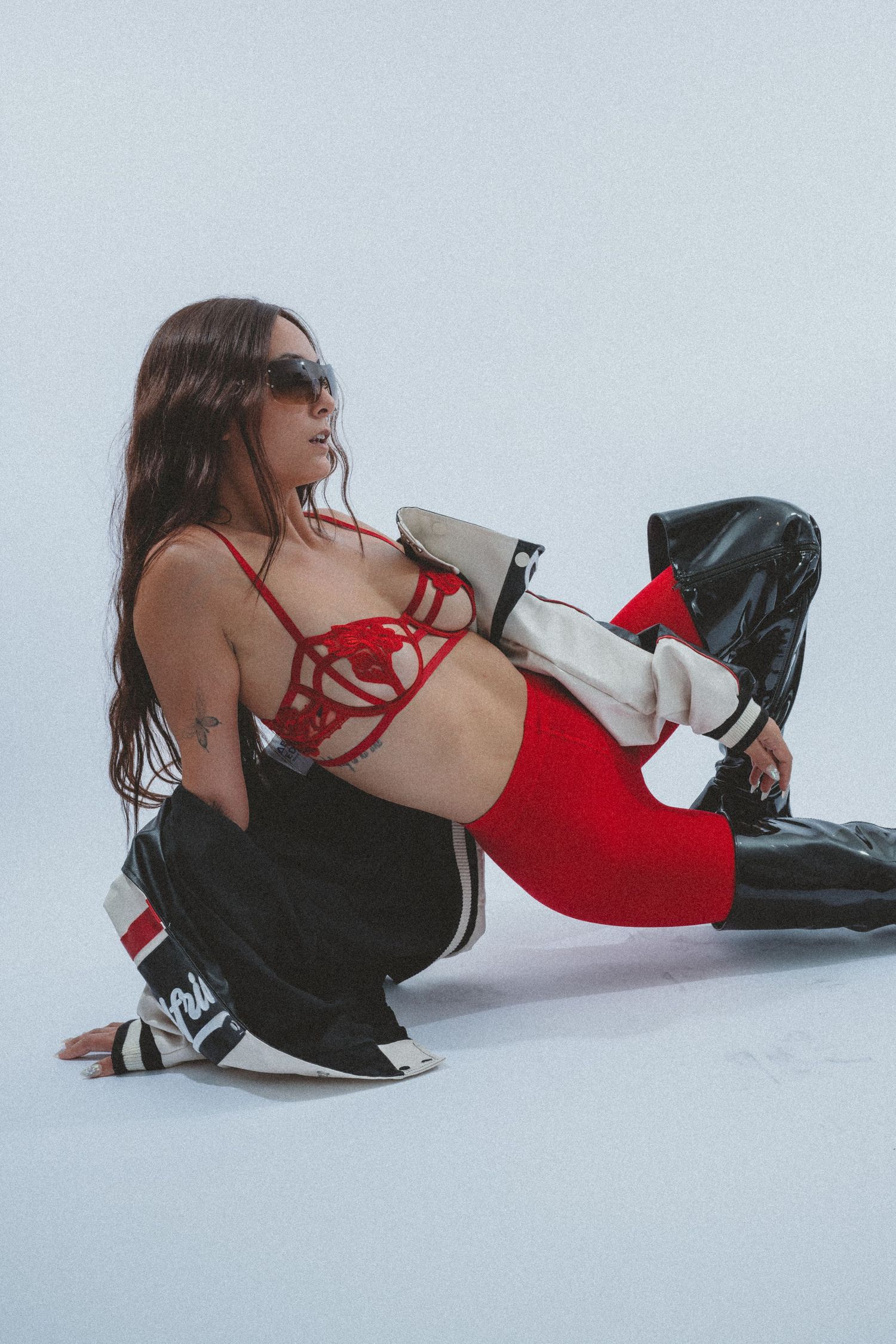 Fashion editorial on white background with red and black styling elements.