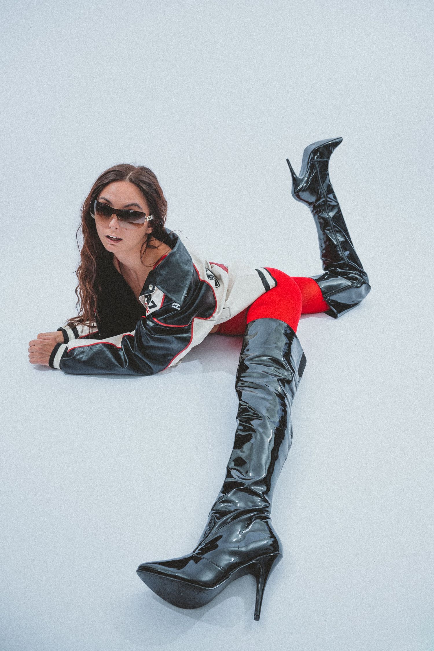Fashion photography featuring black patent leather boots against a white background.