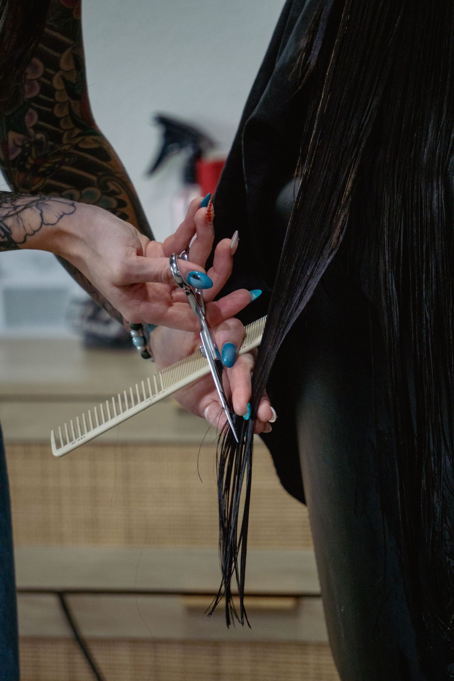 Close-up of hands holding hair styling tools during a haircut session.