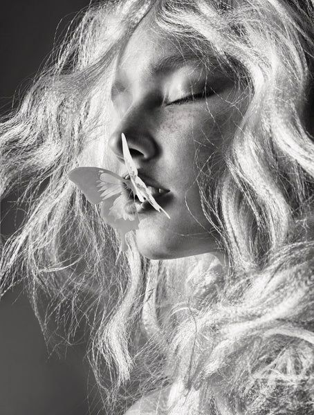 Artistic black and white close-up of flowing blonde hair against a light background.