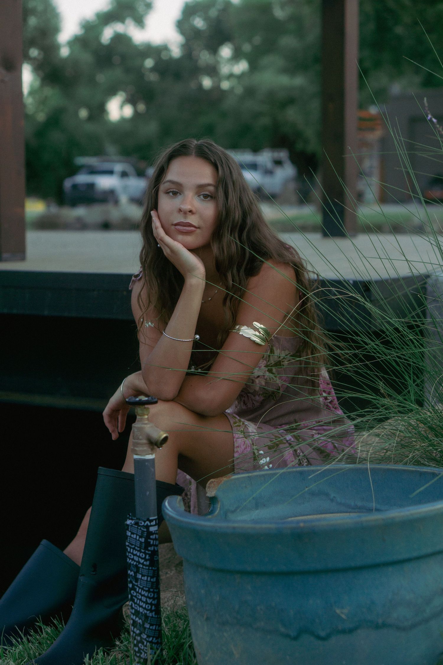A dreamy outdoor portrait session near a decorative blue planter with ornamental grasses.