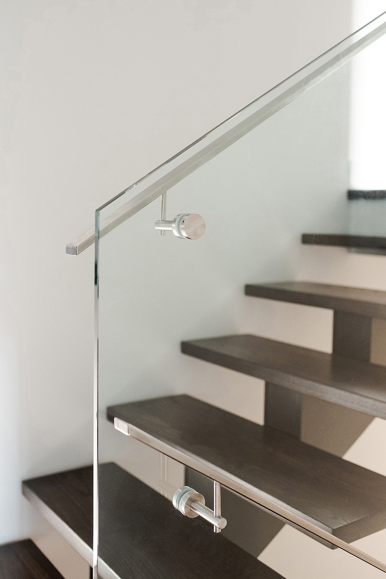 Modern wooden staircase with sleek metal handrail and minimalist design.