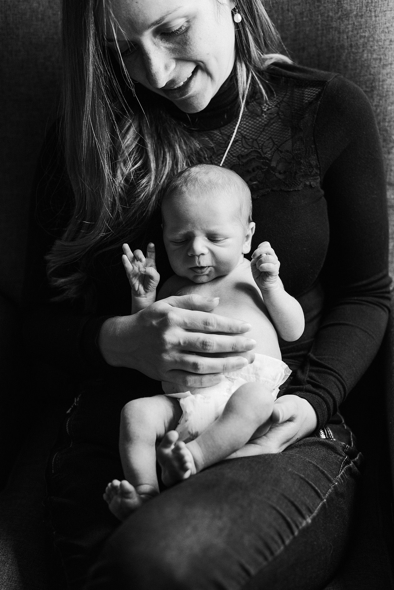Black and white photo series showing tender moments between parent and infant in intimate close-up shots.