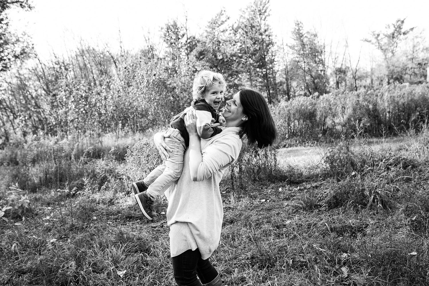Black and white outdoor portrait in a natural field setting.