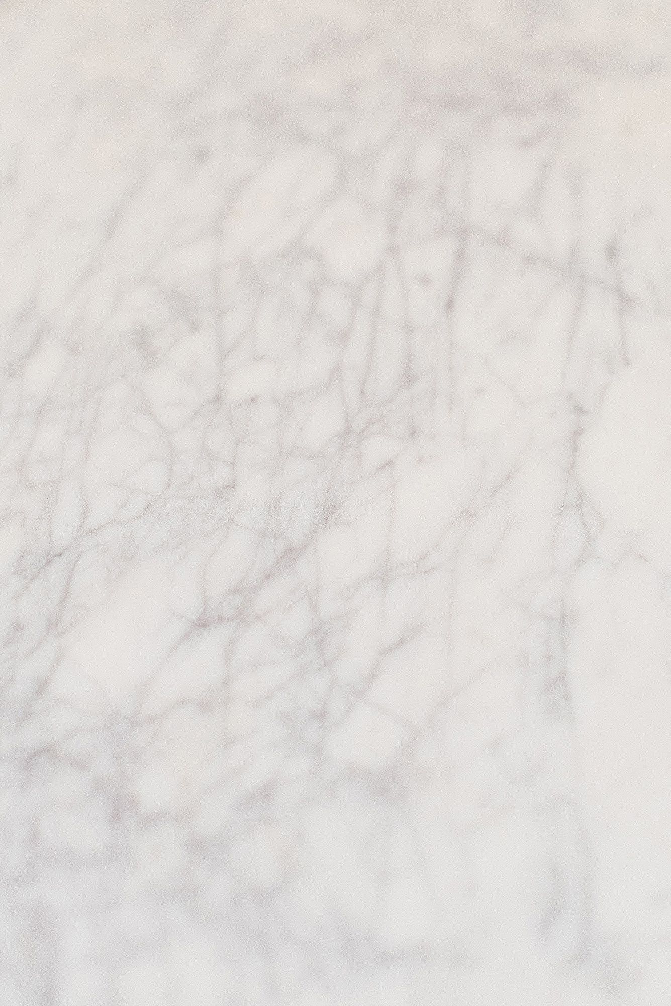 Close-up detail of white marble surface showing delicate natural veining patterns and textures.