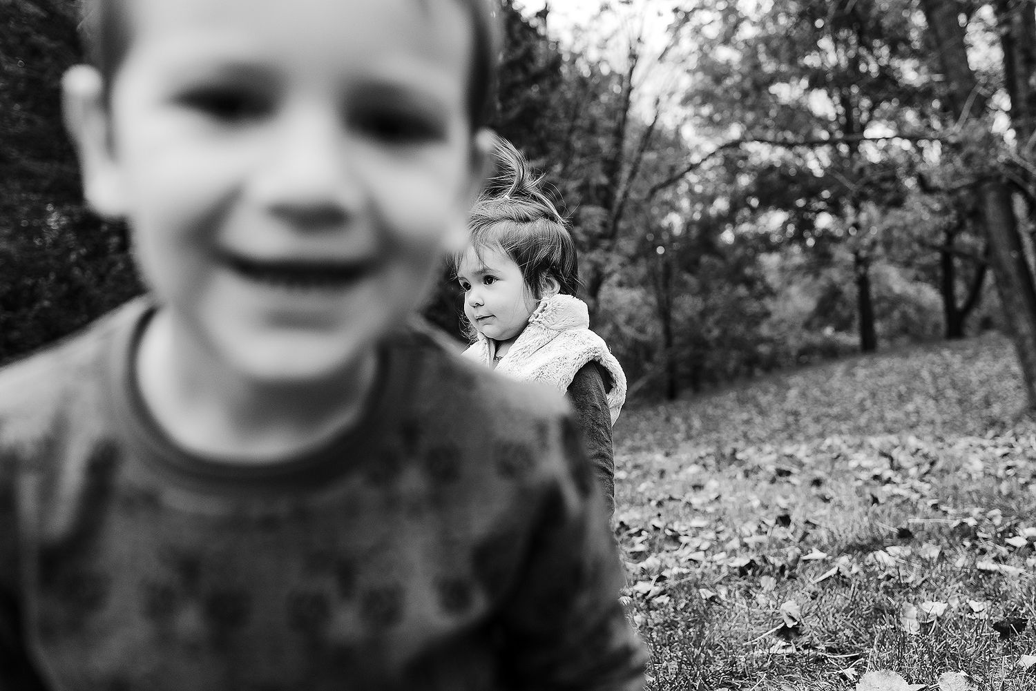 A series of black and white photographs showing joyful expressions and playful moments in an outdoor setting.