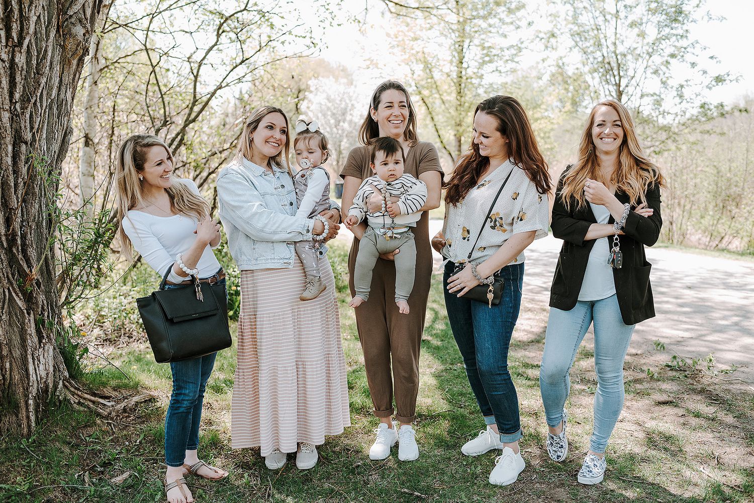 Group photo session outdoors with multiple people standing together in casual attire.