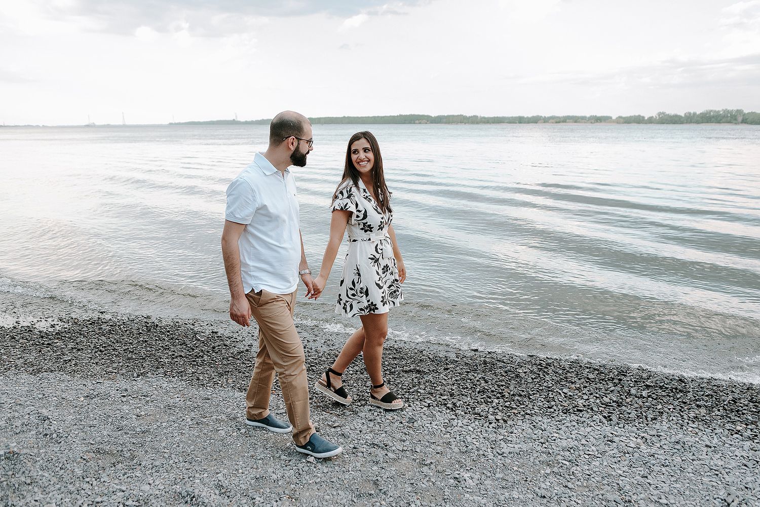 Couple walking and playing together along a scenic beach shoreline.