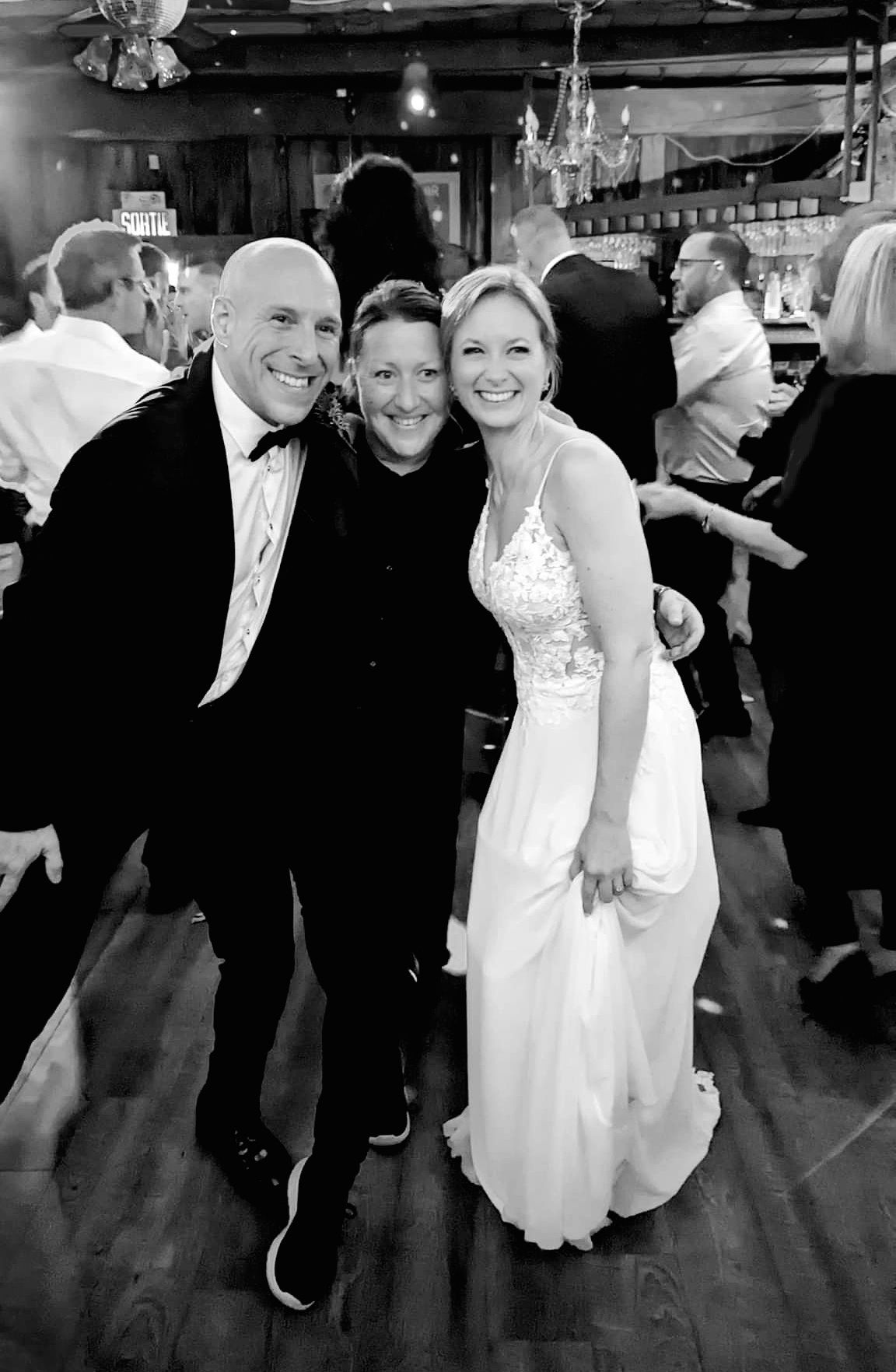 Wedding celebration with people dancing and enjoying festivities on a dance floor.