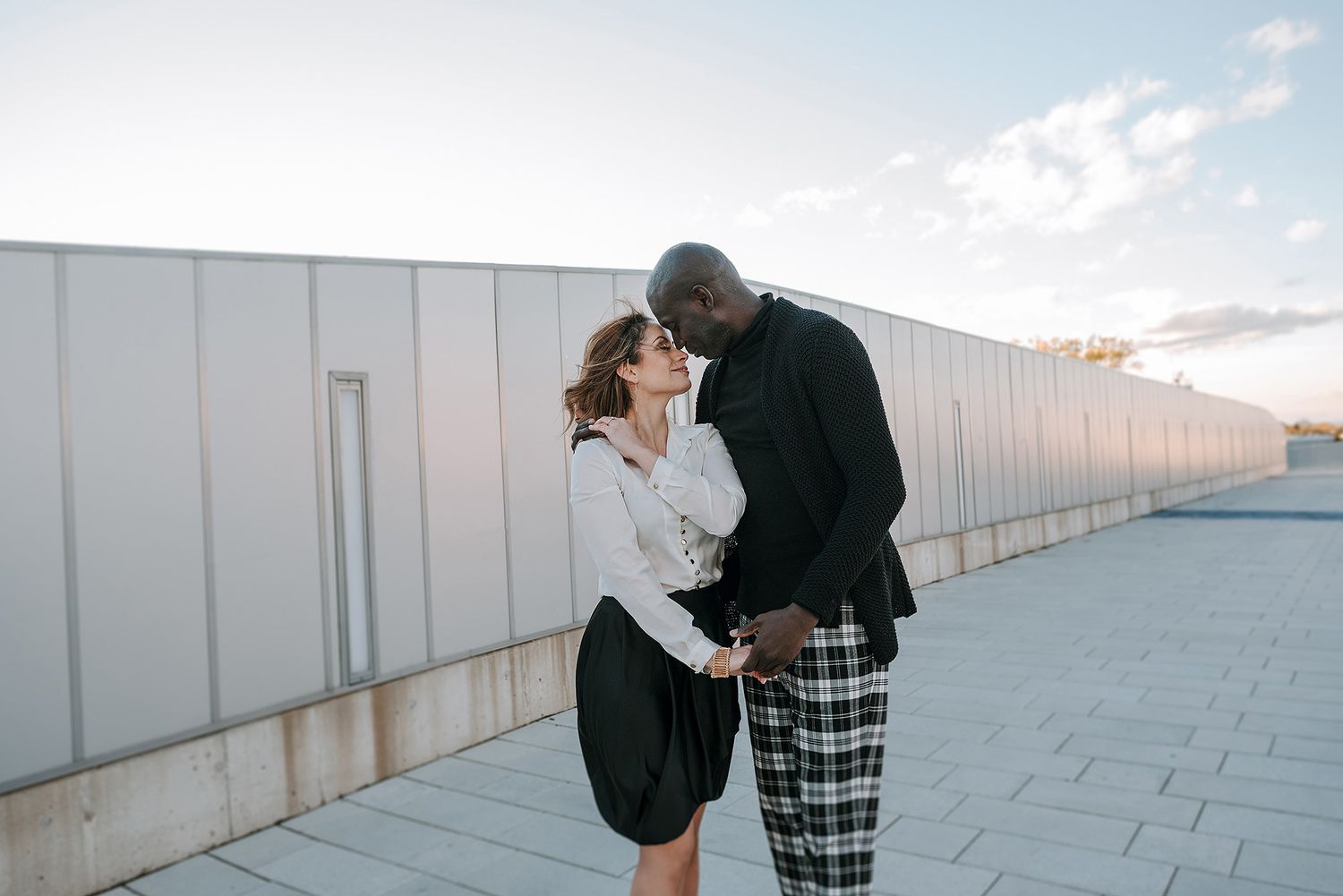 Modern minimalist couple portraits against white walls and sky backdrop.
