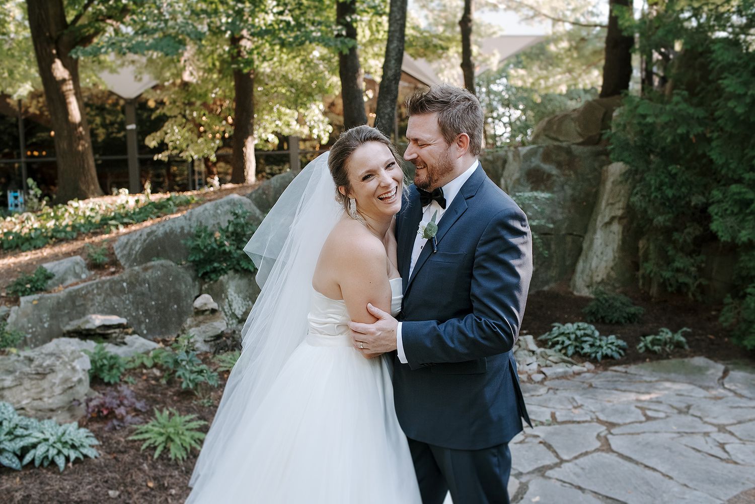 A romantic wedding photoshoot sequence showing a couple embracing in a garden setting with stone pathways.