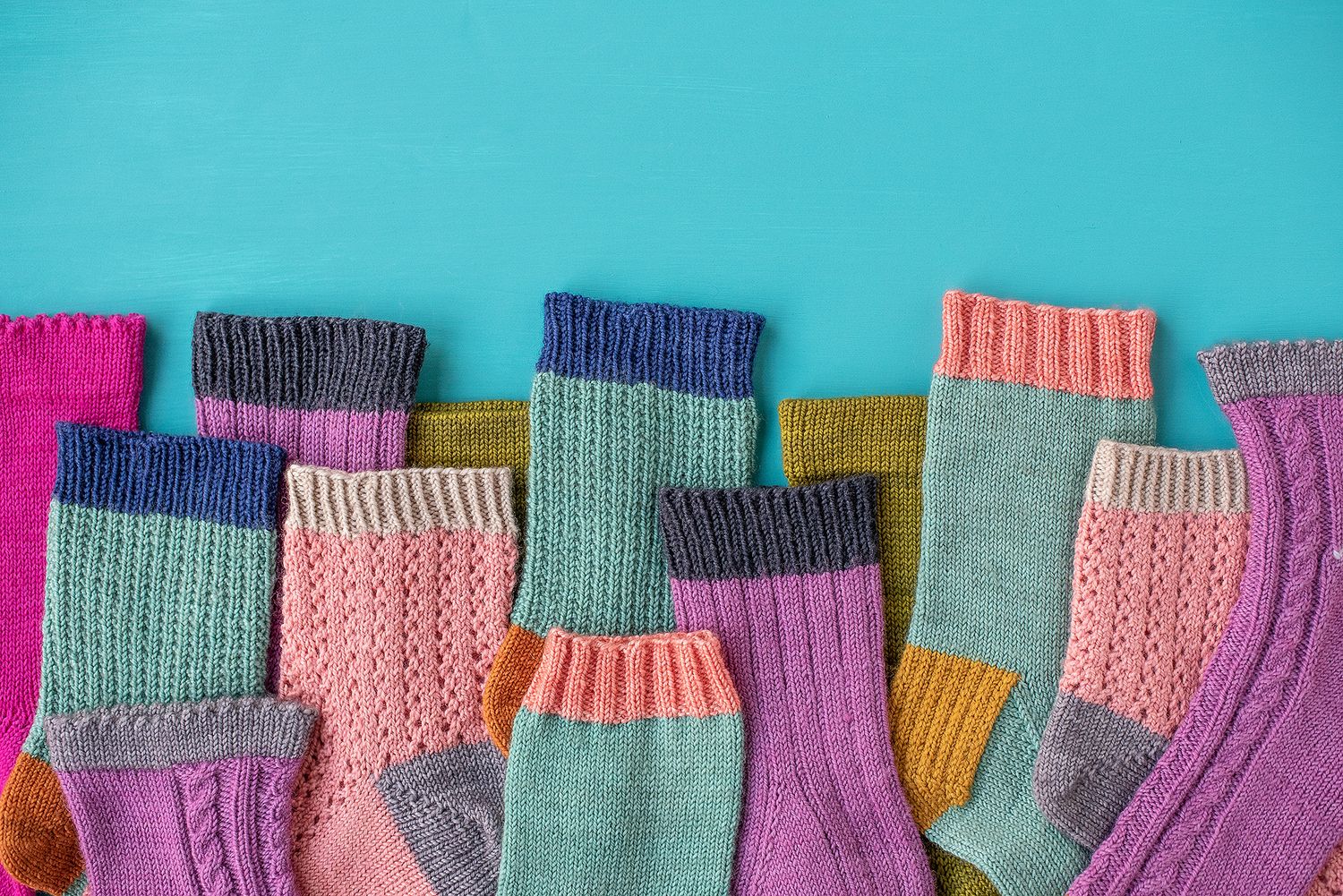 Colorful knitted fabric swatches arranged in rows against a turquoise background.