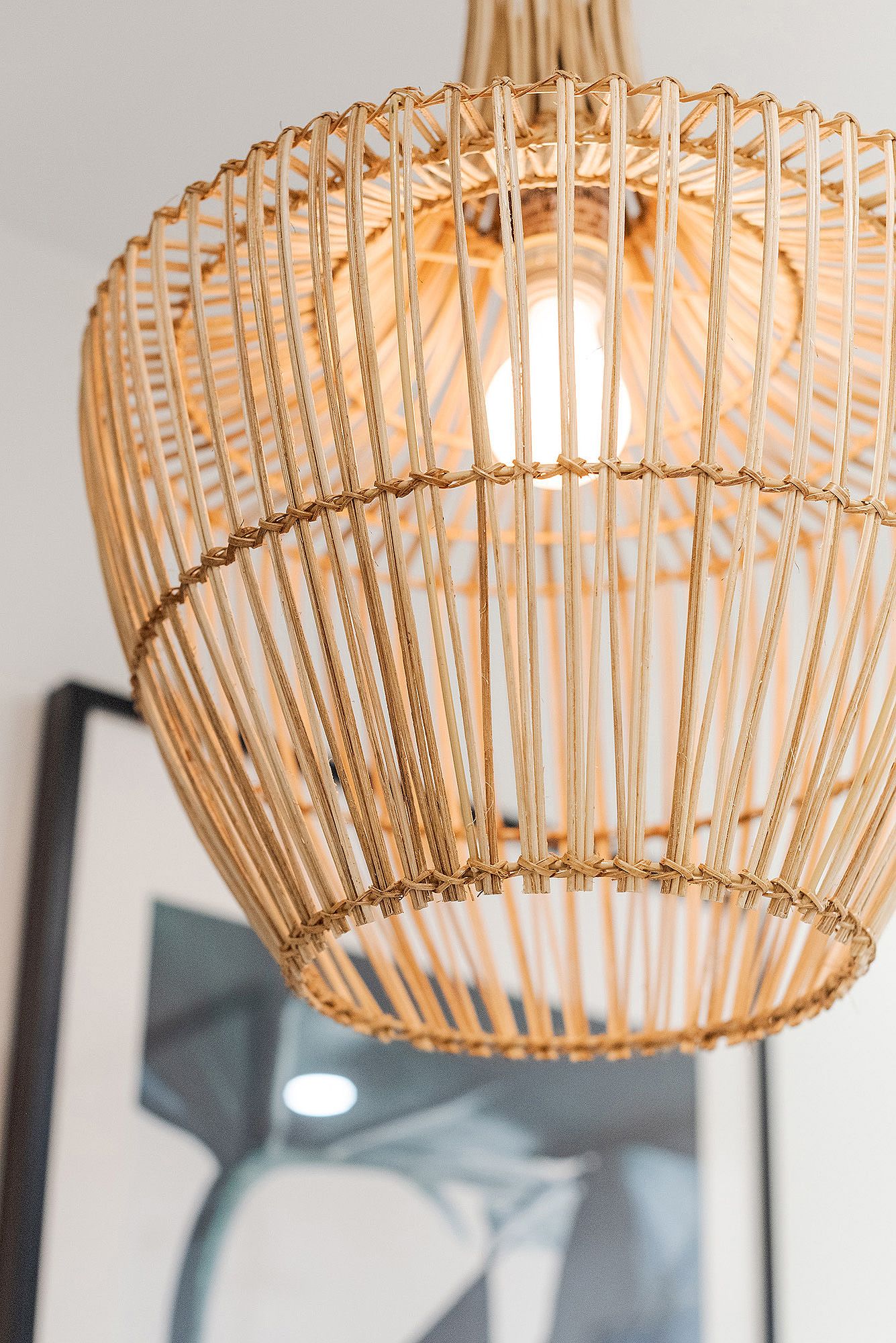 Modern rattan pendant lights with dome shapes hang from the ceiling creating warm ambient lighting in an interior space.