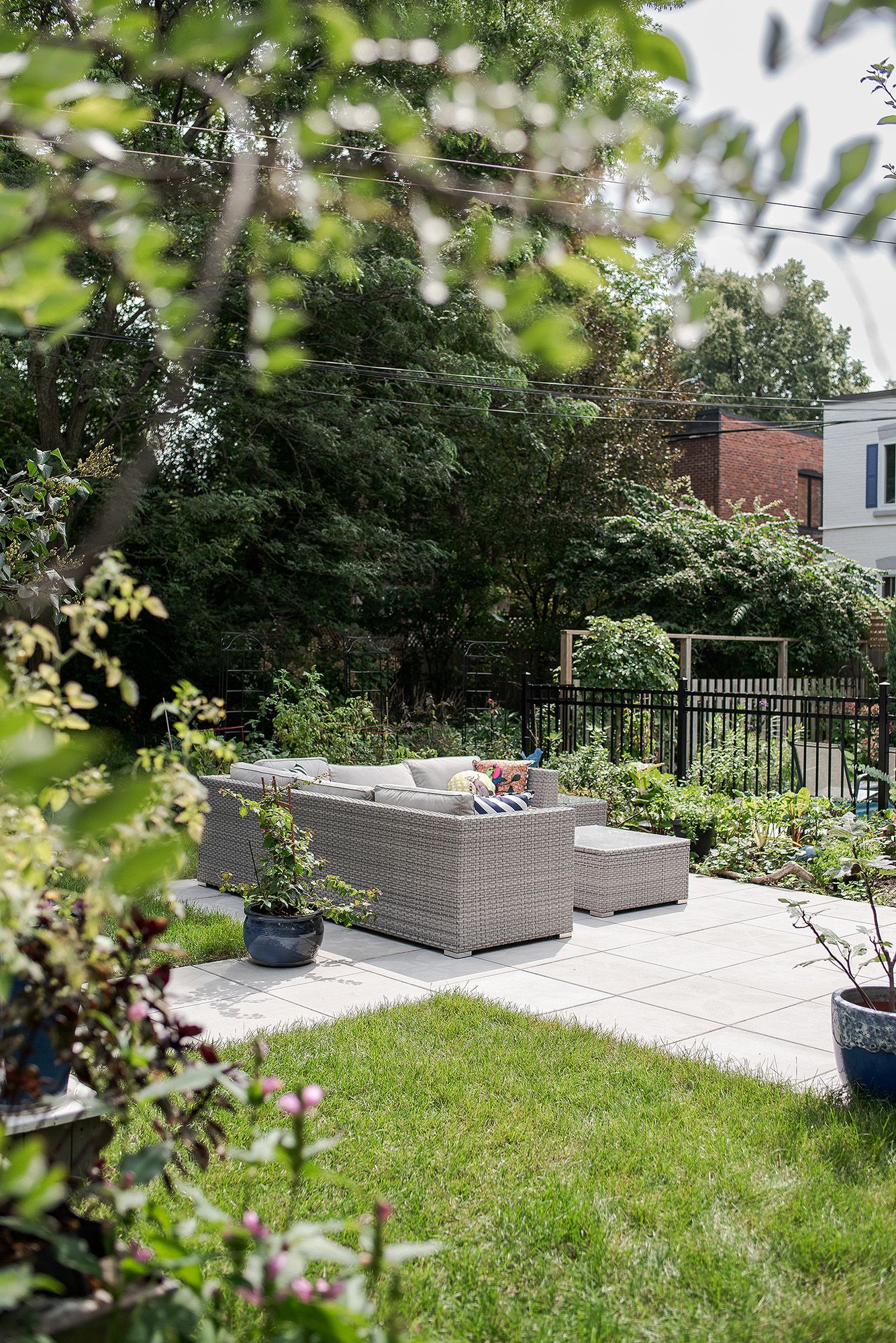 Modern outdoor patio space featuring raised planter boxes and comfortable seating areas surrounded by lush greenery.
