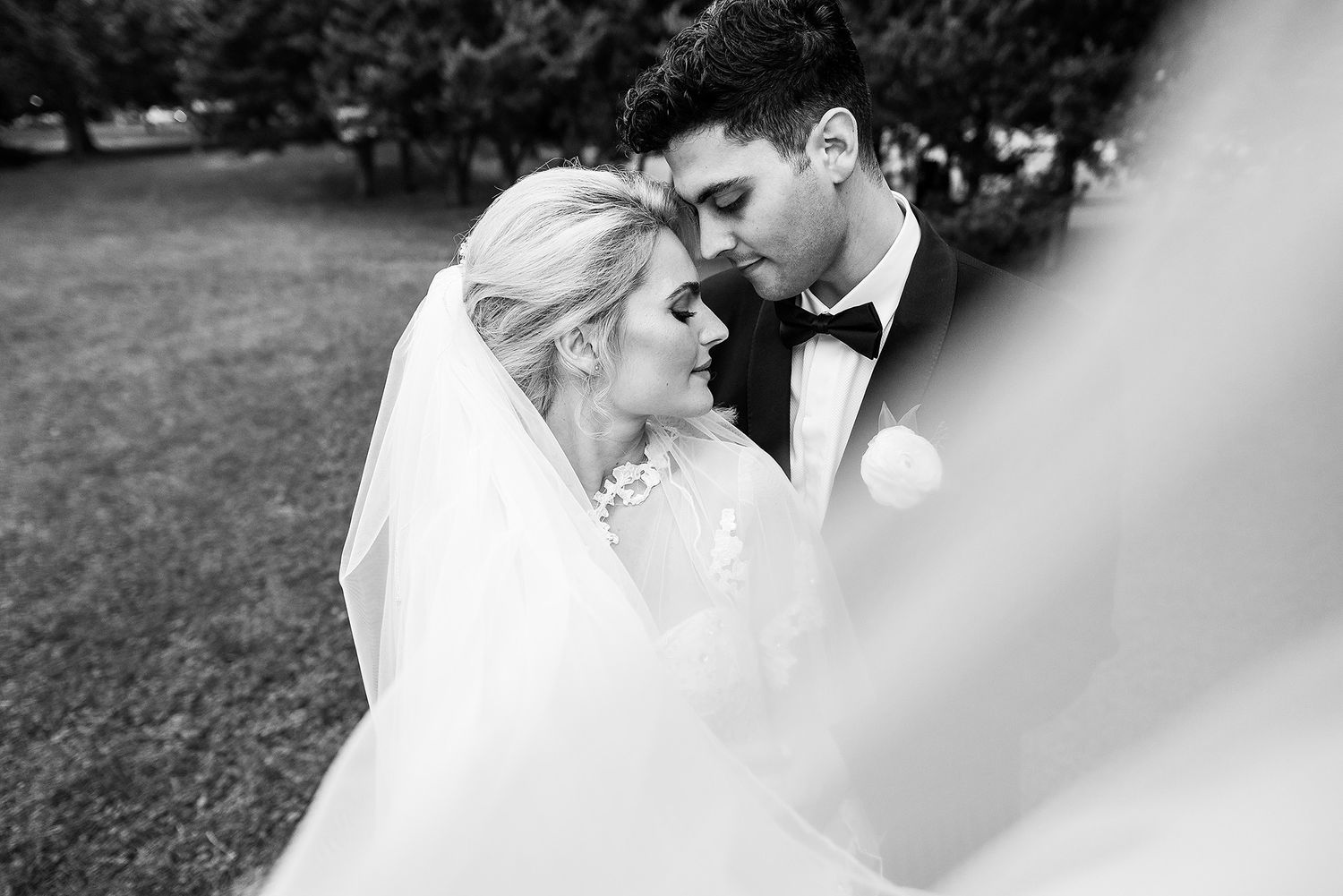 A romantic wedding couple shares tender moments in black and white photographs.