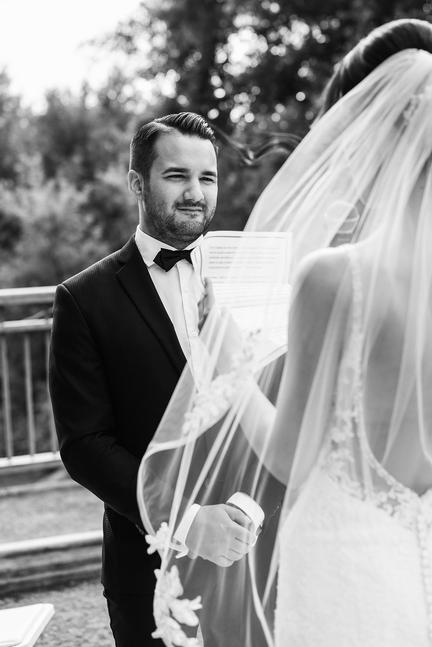 Black and white wedding photo series showing tender moments between bride and groom with flowing veil outdoors.