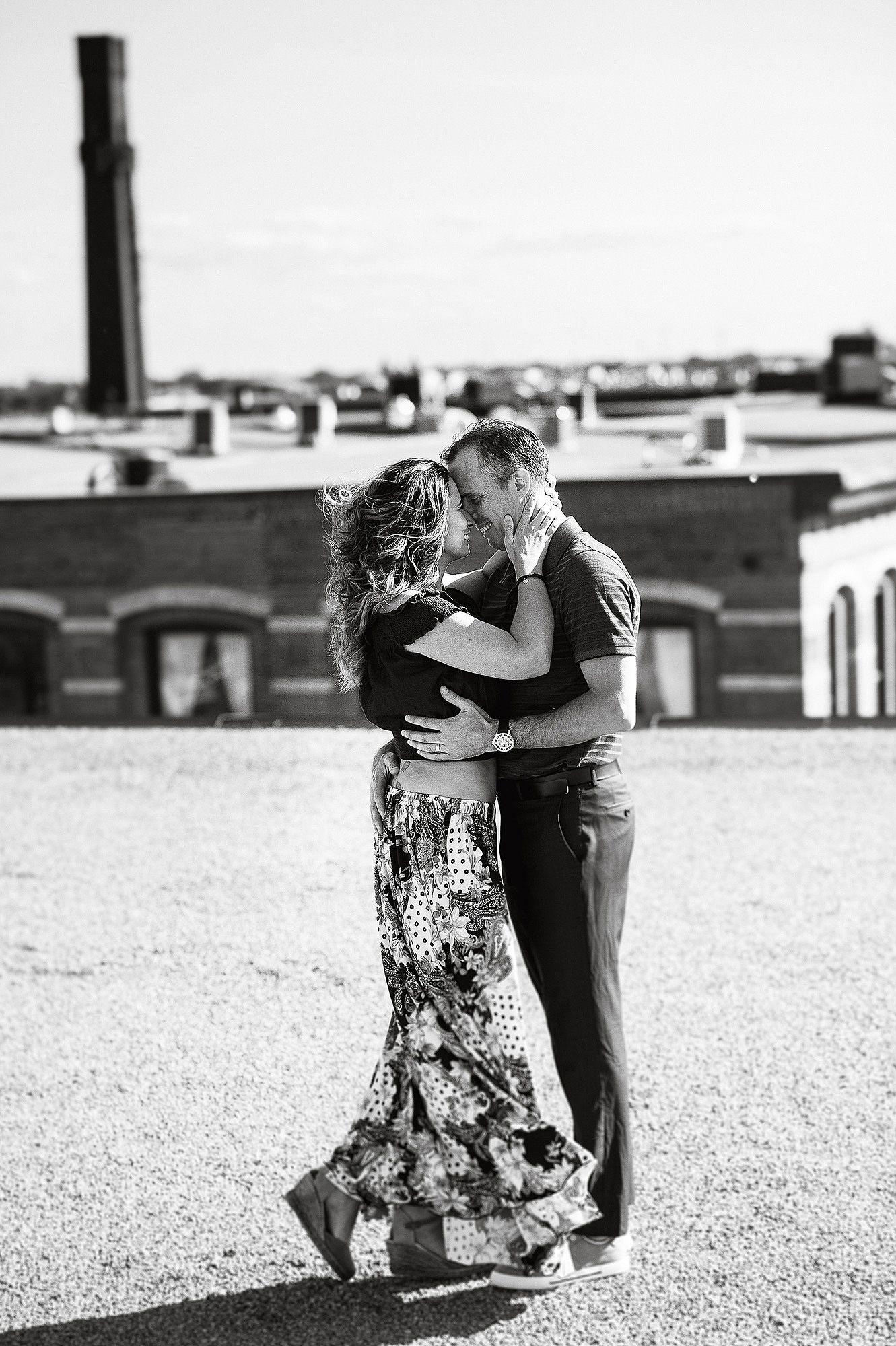 Black and white photos of a couple dancing and embracing on an urban rooftop.