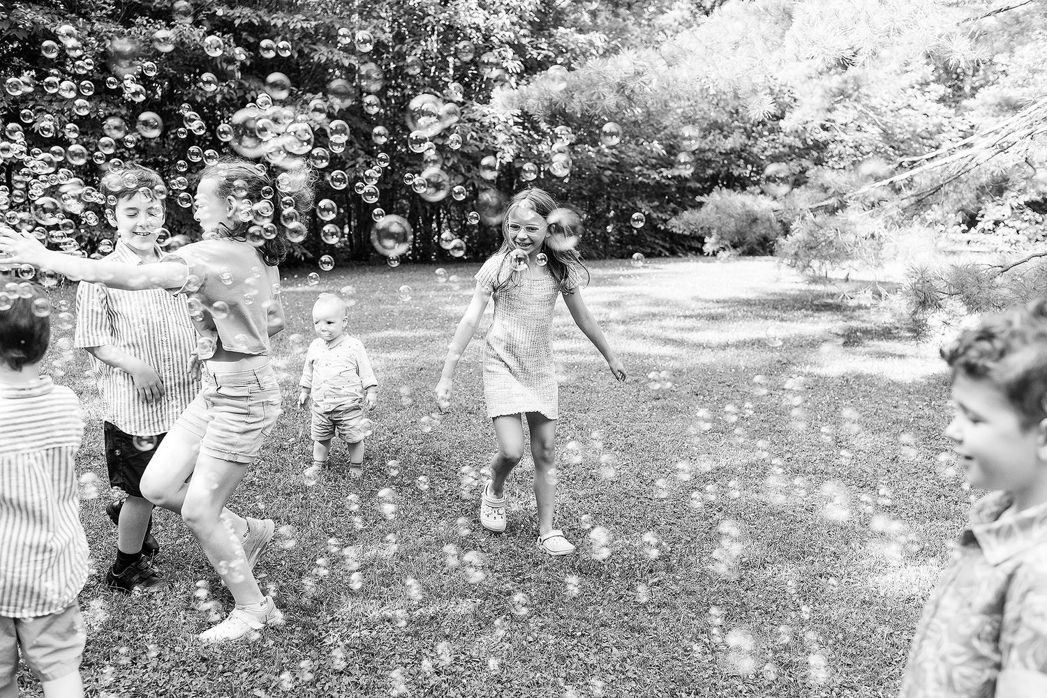 People playing and throwing white flower petals in the air during an outdoor celebration.