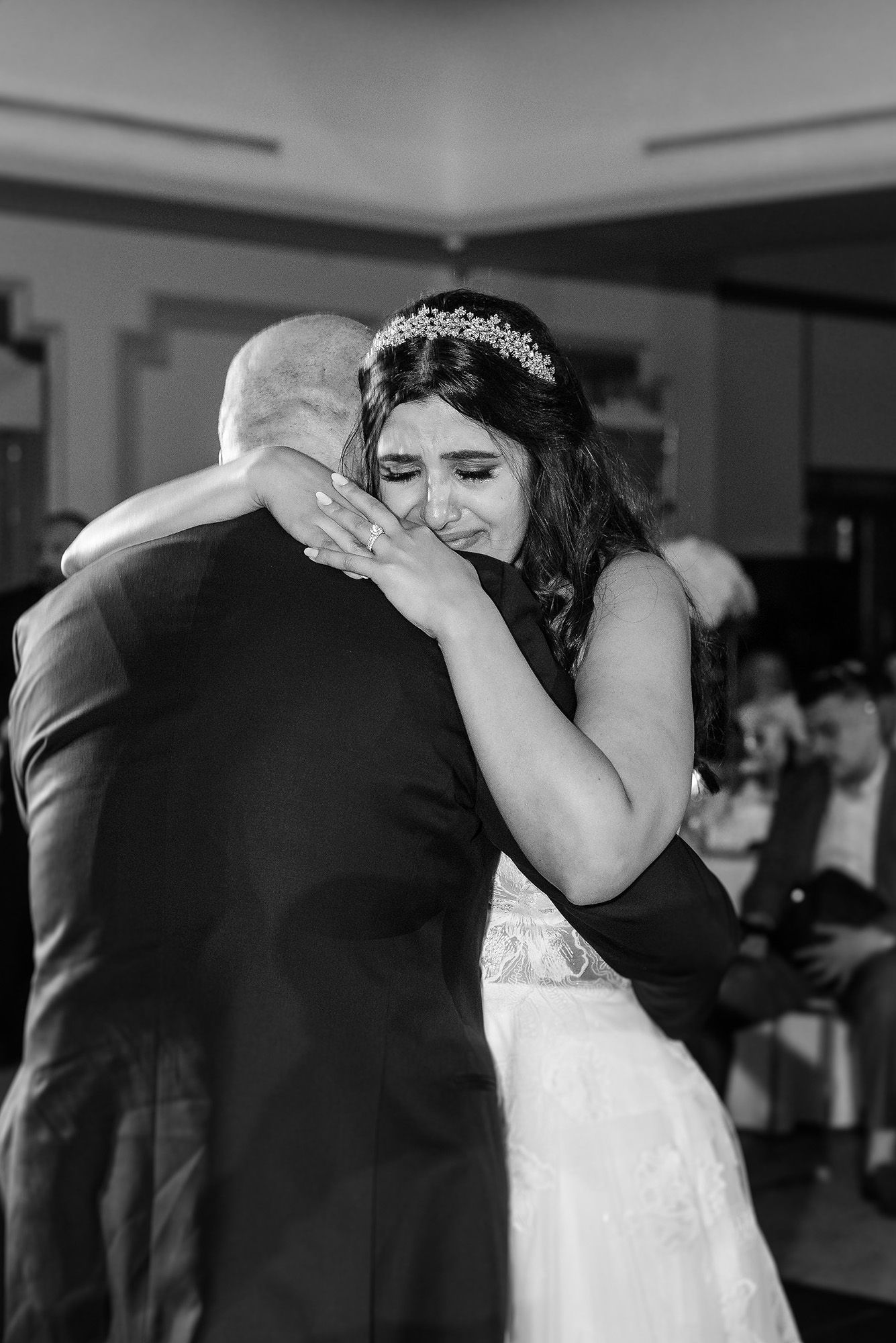 A couple performs an elegant dance move during their first dance at a wedding reception.