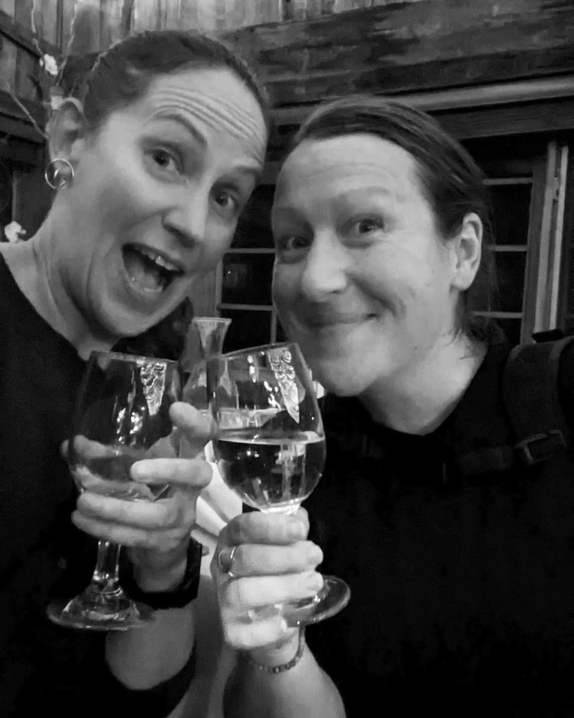 Two friends enjoying drinks together in black and white photography.