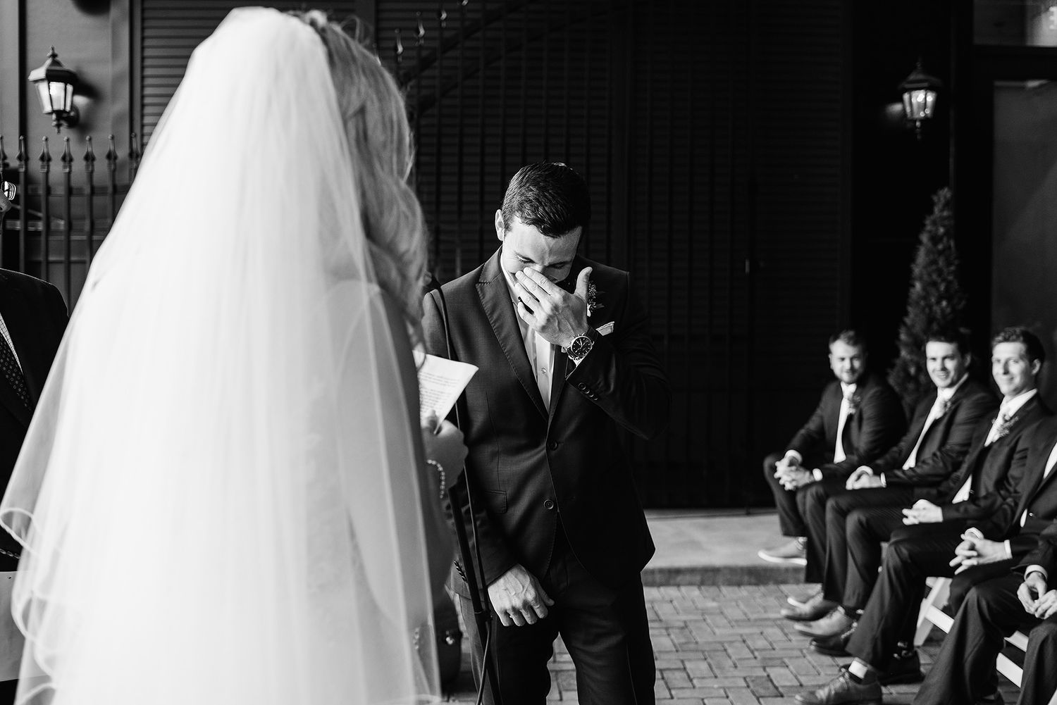 A black and white panoramic wedding photo showing a bride in a flowing veil walking down a church aisle.