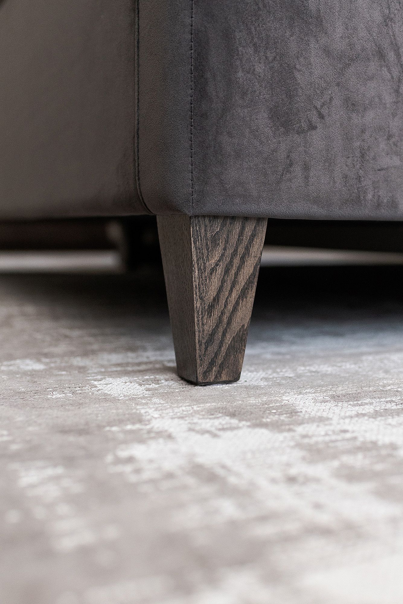 A series of minimalist images showing a dark wooden furniture leg against a light floor creating a subtle shadow effect.