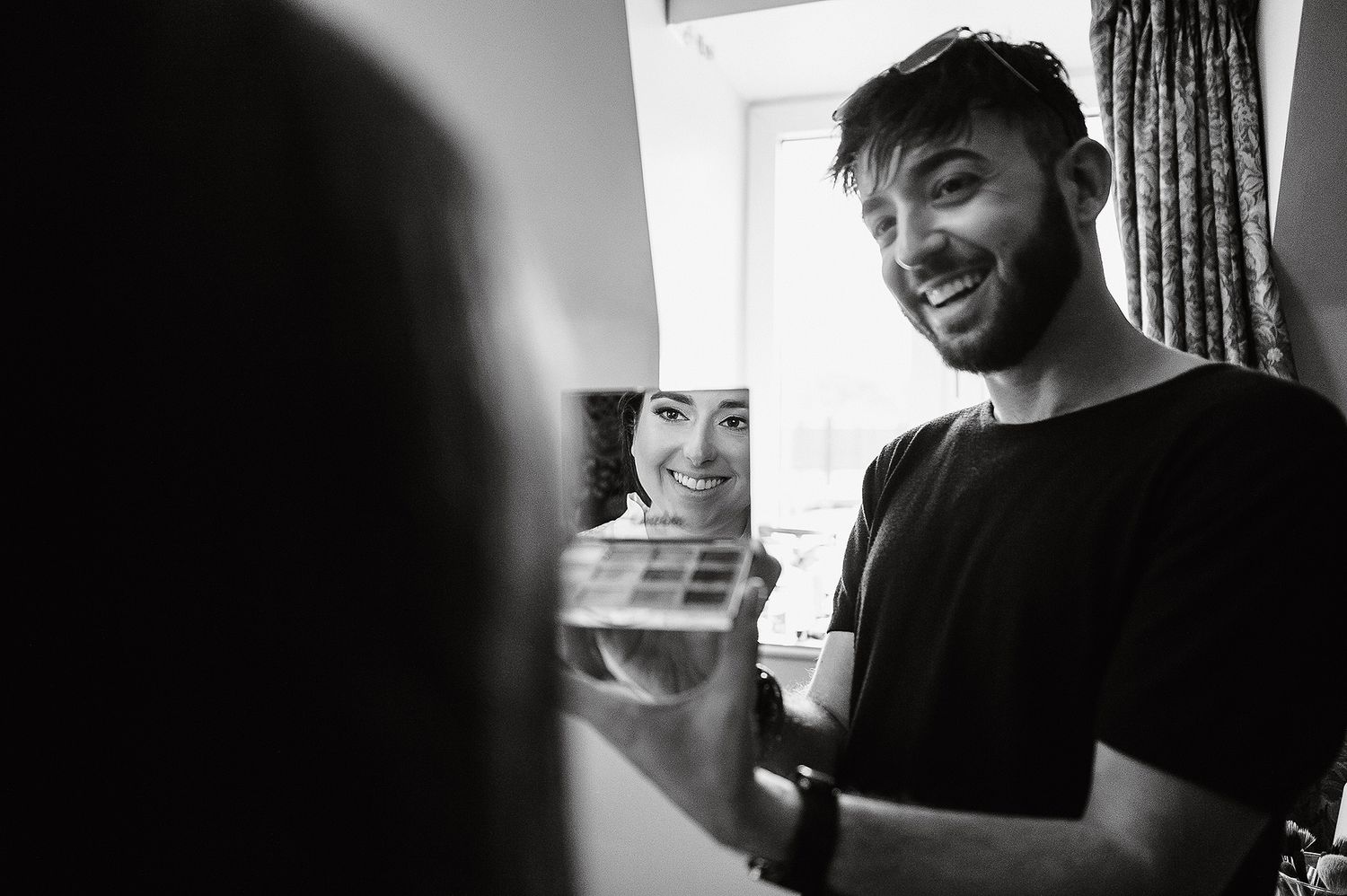 A black and white photo montage showing candid moments of people laughing and smiling in various settings.