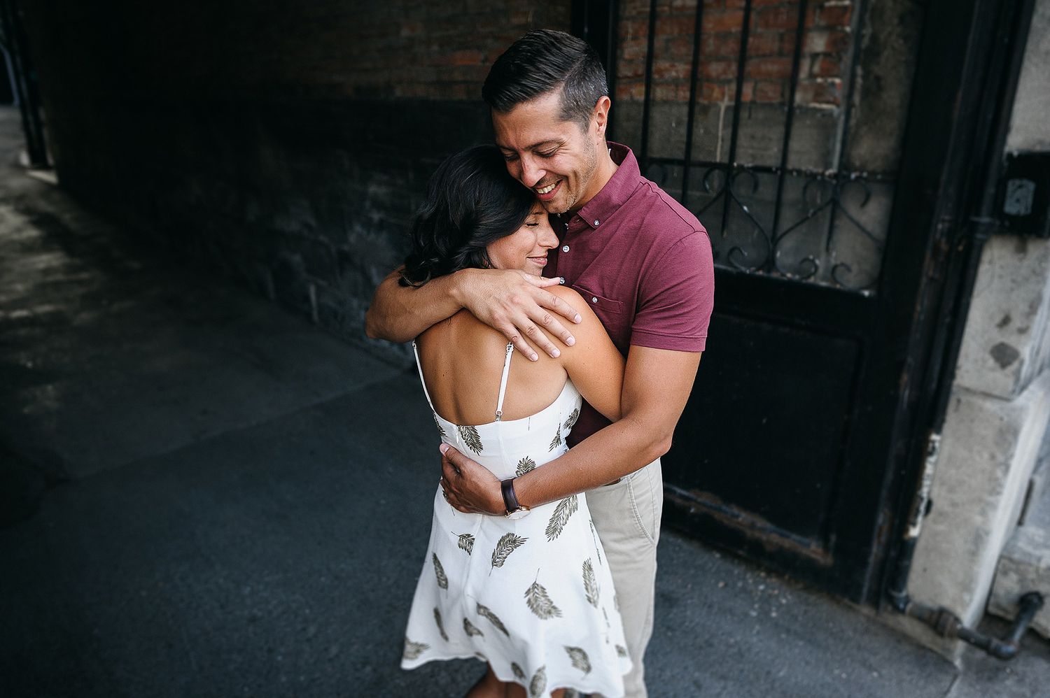 Affectionate couple sharing playful moments against an industrial backdrop.