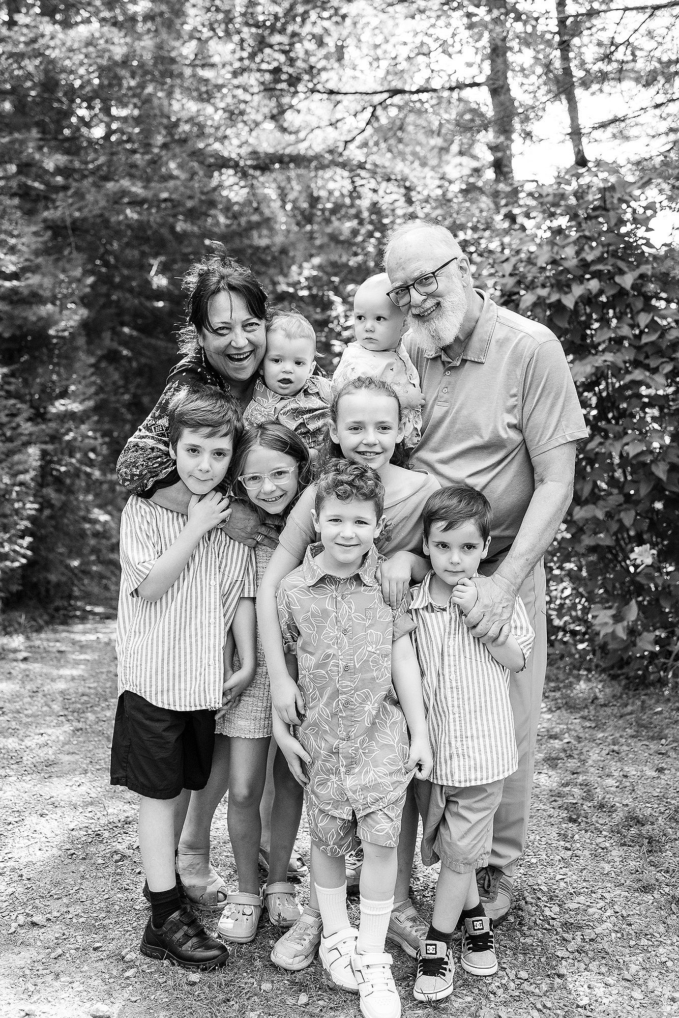A group in coordinated outfits poses together outdoors in a black and white candid photo series.