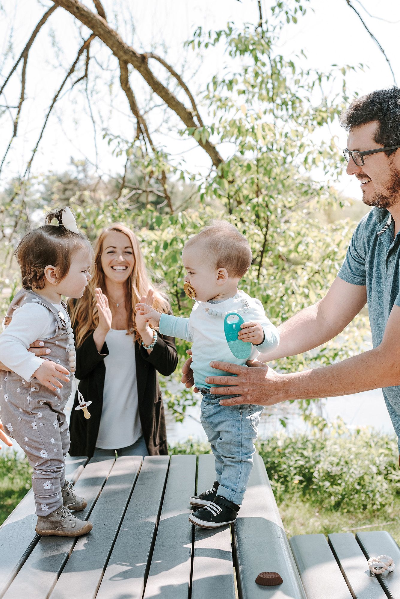 Happy family interactions captured in sequence during an outdoor gathering by the lake.