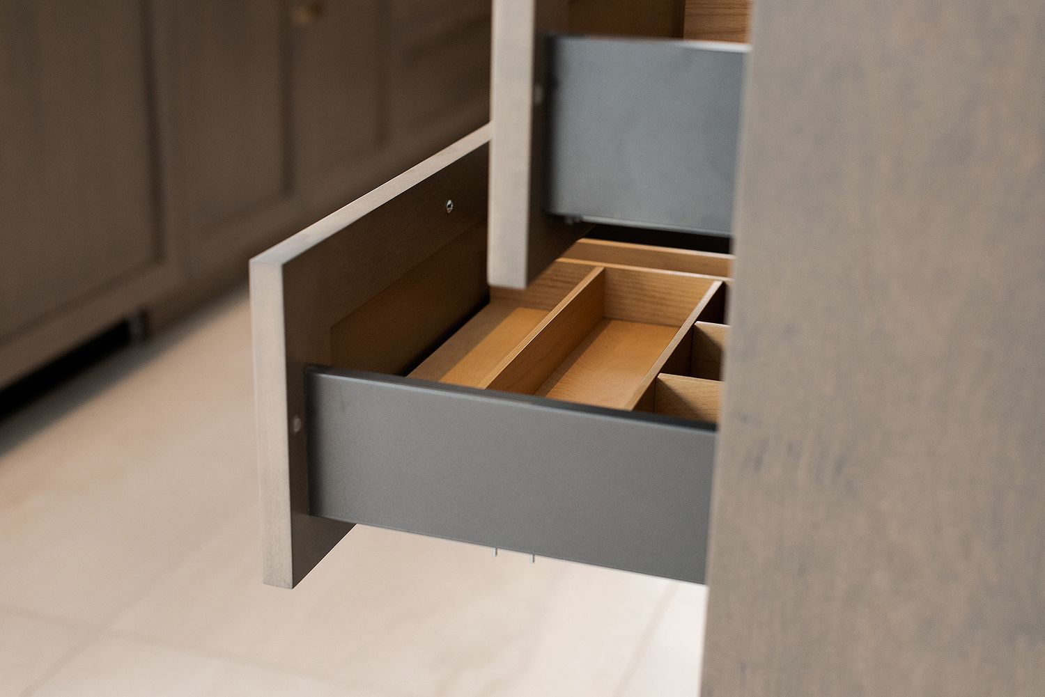 Close-up detail of white kitchen cabinetry and countertop edge showing contemporary minimalist design elements.