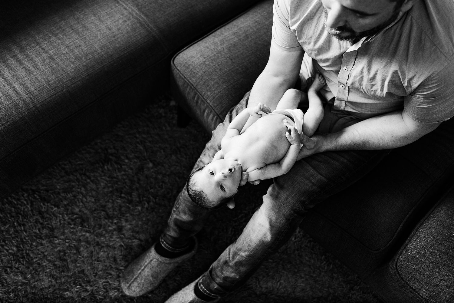 Intimate black and white newborn photography sequence on dark background.