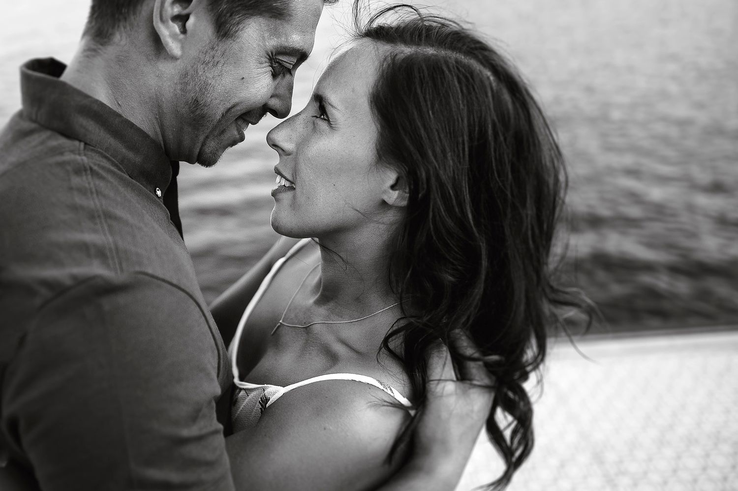 Black and white waterfront portraits capturing intimate moments at sunset.