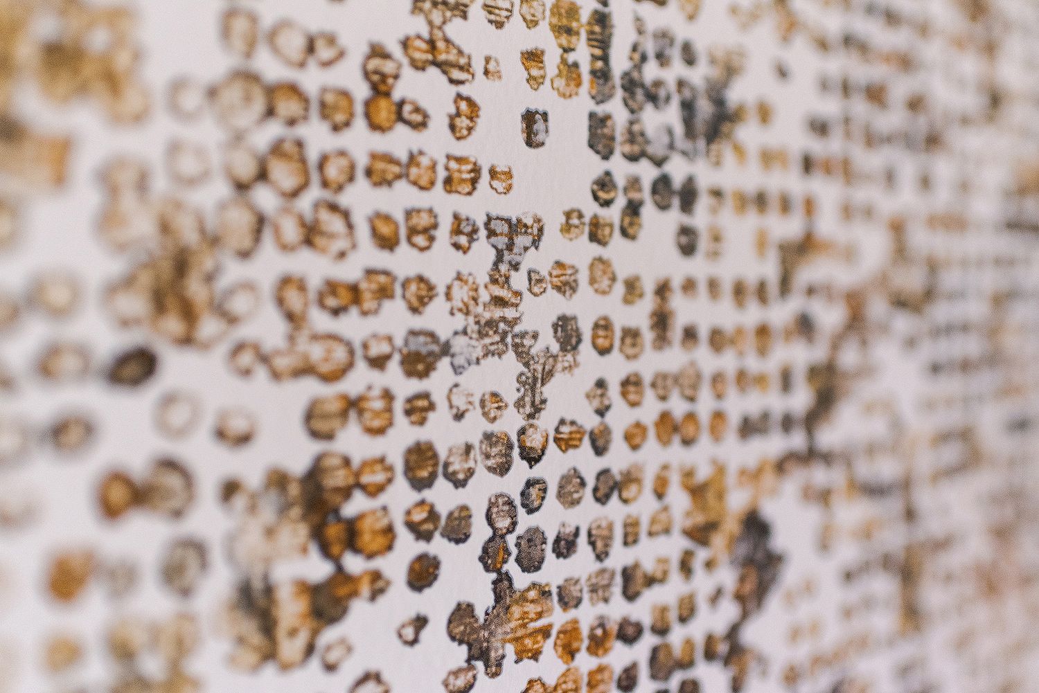Close-up of a textured beige wall with repetitive circular pattern creating a dotted effect.