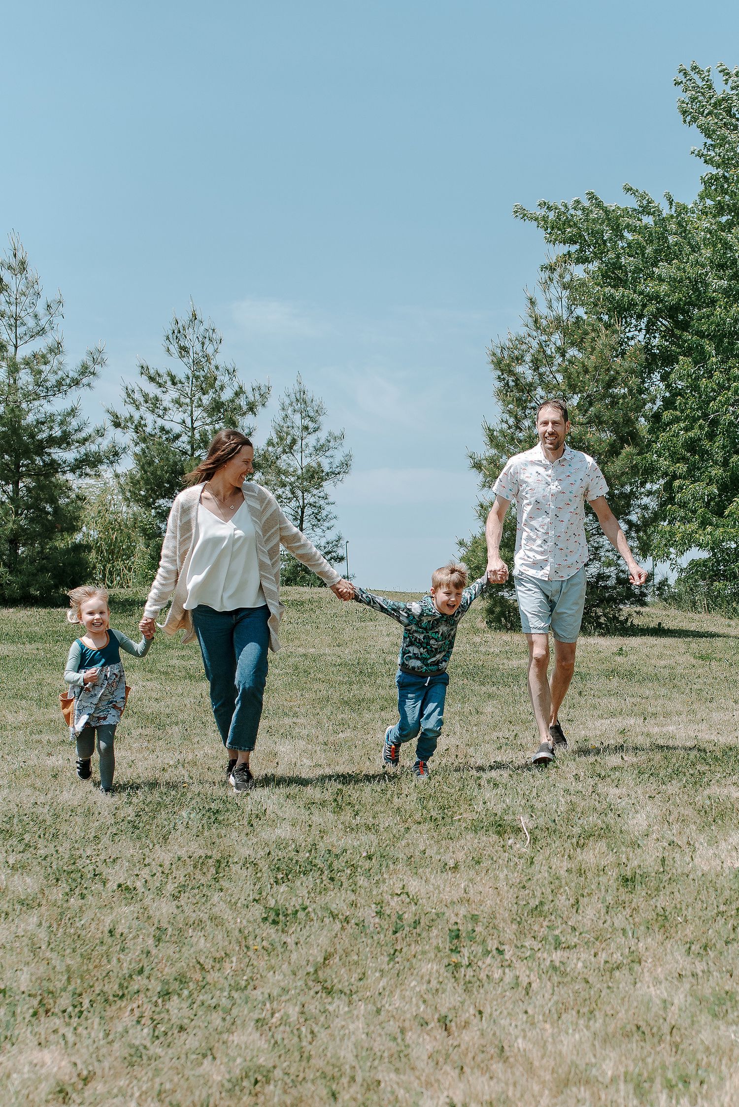 A sequence of playful running moments on a grassy hillside on a sunny summer day.