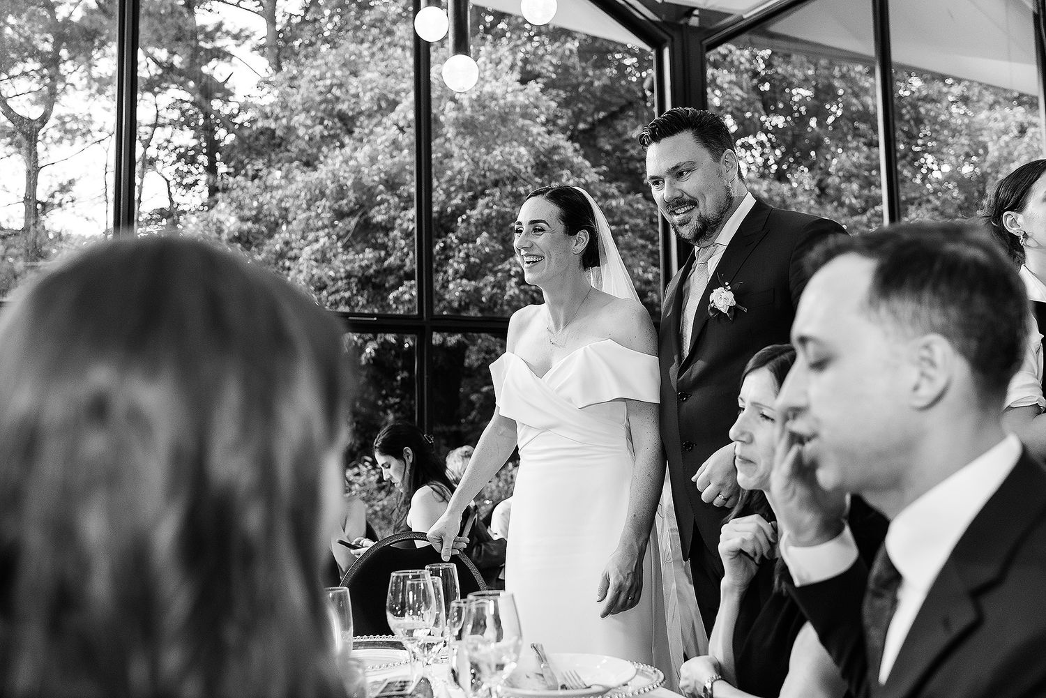 Black and white candid wedding reception photos showing guests and newlyweds celebrating outdoors.