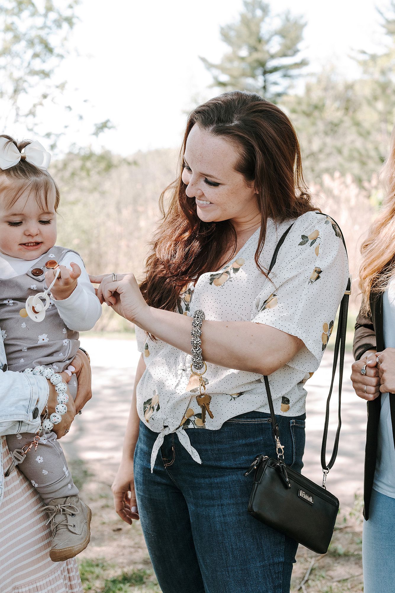 Series of images showing a stylish diaper bag and baby accessories in an outdoor setting.