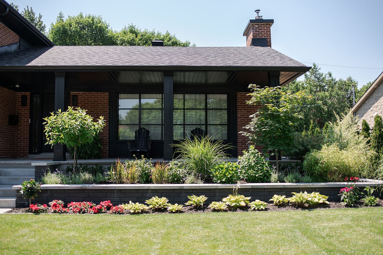 Modern ranch-style home exterior with landscaped garden and expansive windows stretches across panoramic view.