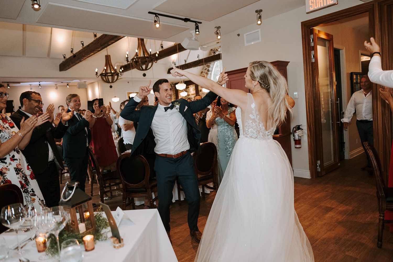 Indoor wedding reception venue with warm lighting and rustic wooden details.