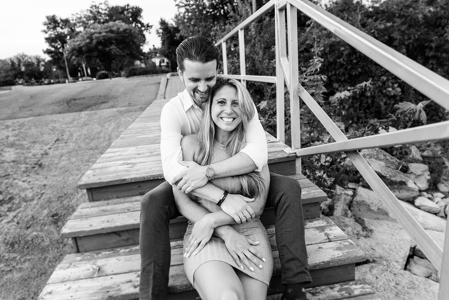 Romantic couple sharing intimate moments on a wooden deck in a series of candid black and white photos.