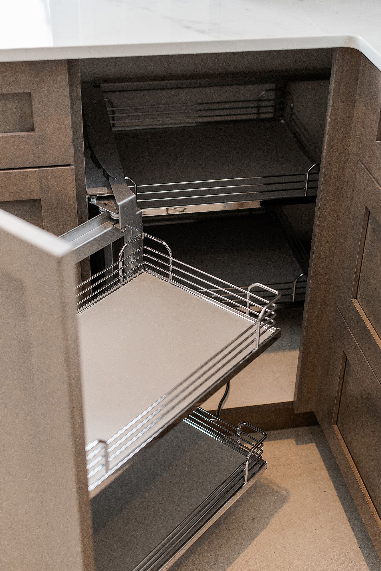 Pull-out corner cabinet organizer with multiple metal shelves for kitchen storage.